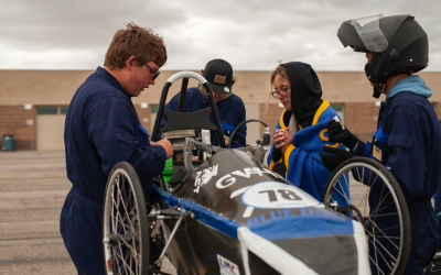 students working on car
