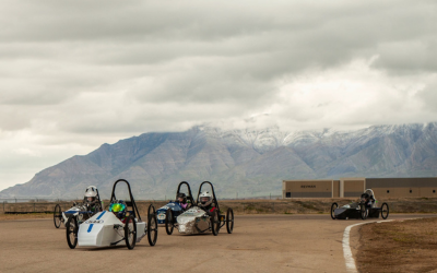 Cars and teams pose for a group photo.