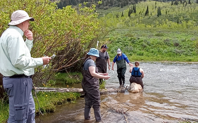Teachers running an experiment on the bank of a river.