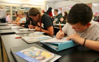 Students in classroom learning how to pay for college.