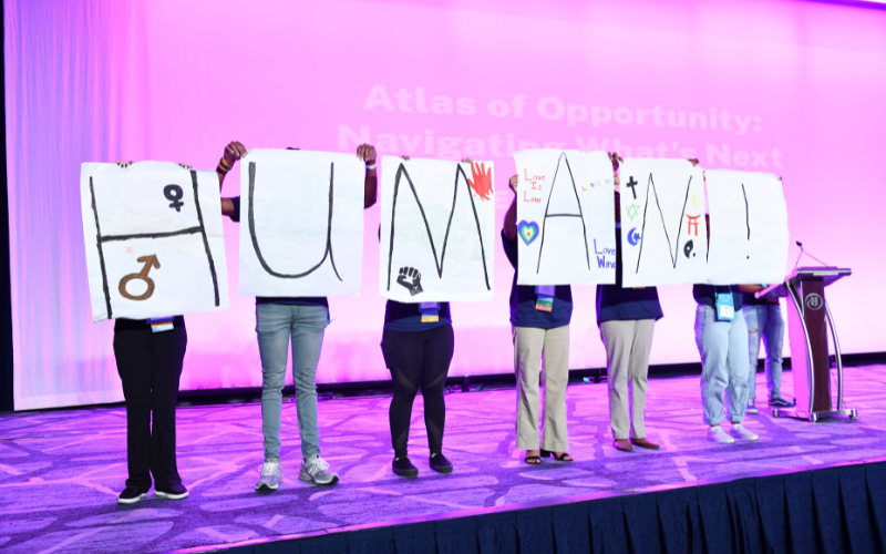 Students presenting posters that spell human.
